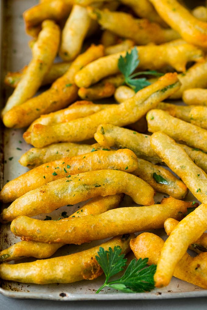 Fried Green Beans Recipe | Green Beans #greenbeans #appetizer #snack #sadud A sheet pan of fried green beans garnished with chopped parsley.