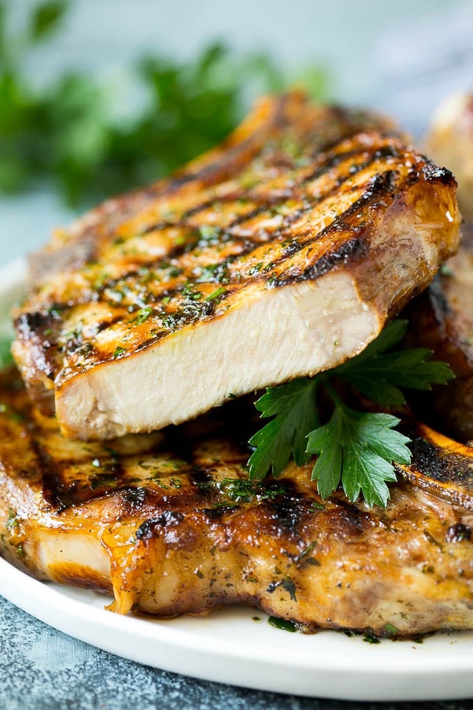 Grilled Pork Chops | Pork Chop Marinade #porkchops #grilling #pork #marinade #dinner #sadud Grilled pork chops with a cut chop on top of the stack.