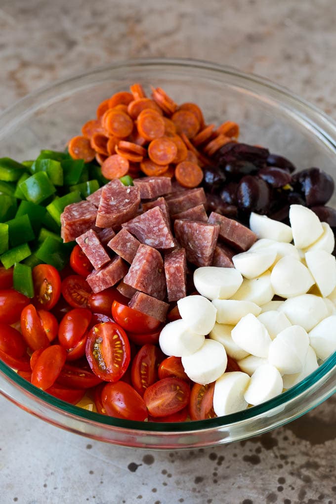 Italian Pasta Salad | Pasta Salad Recipe #pasta #salad #pastasalad #pepperoni #salami #olives #cheese #sidedish #sadud A bowl of pasta, mozzarella balls, cherry tomatoes, bell peppers and olives.