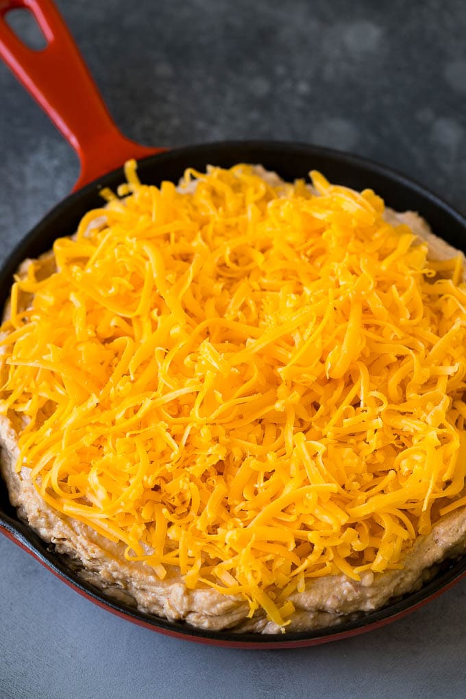 Bean Dip Recipe | Mexican Dip #dip #appetizer #mexicanfood #beans #cheese #sadud The base topped with freshly shredded cheese.