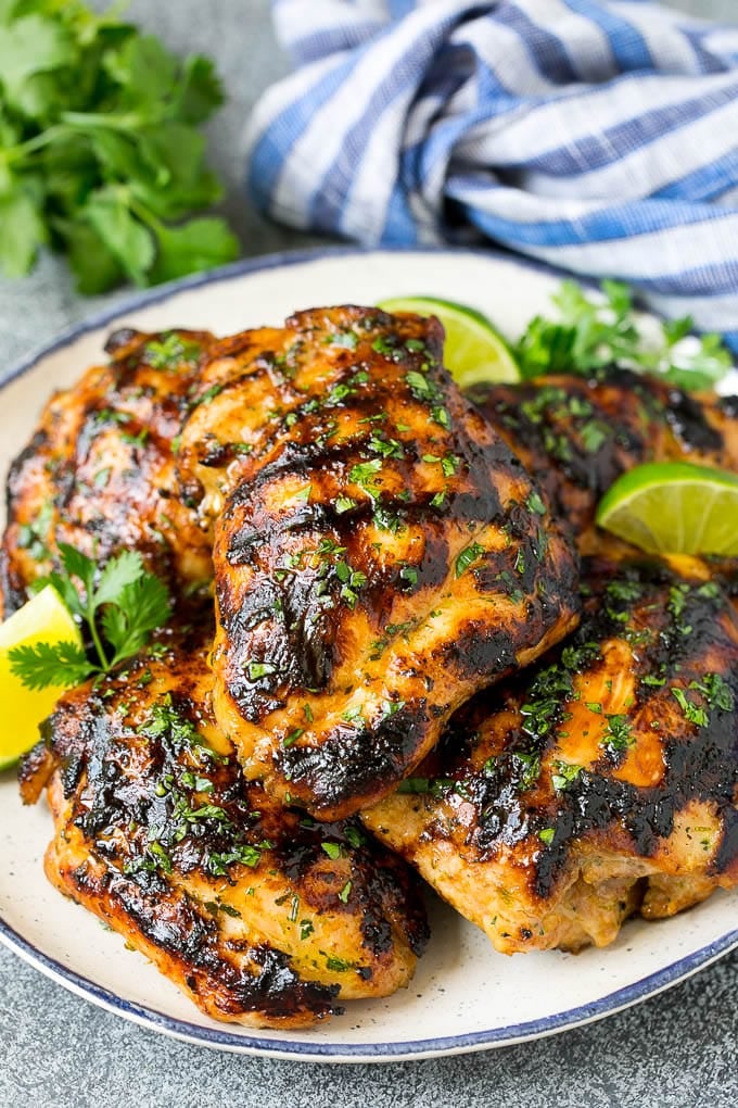 Grilled Chicken Thighs Recipe | Marinated Chicken Thighs #chicken #grilling #marinade #dinner #cilantro #lime #sadud Grilled chicken thighs with a garnish of cilantro and lime wedges.