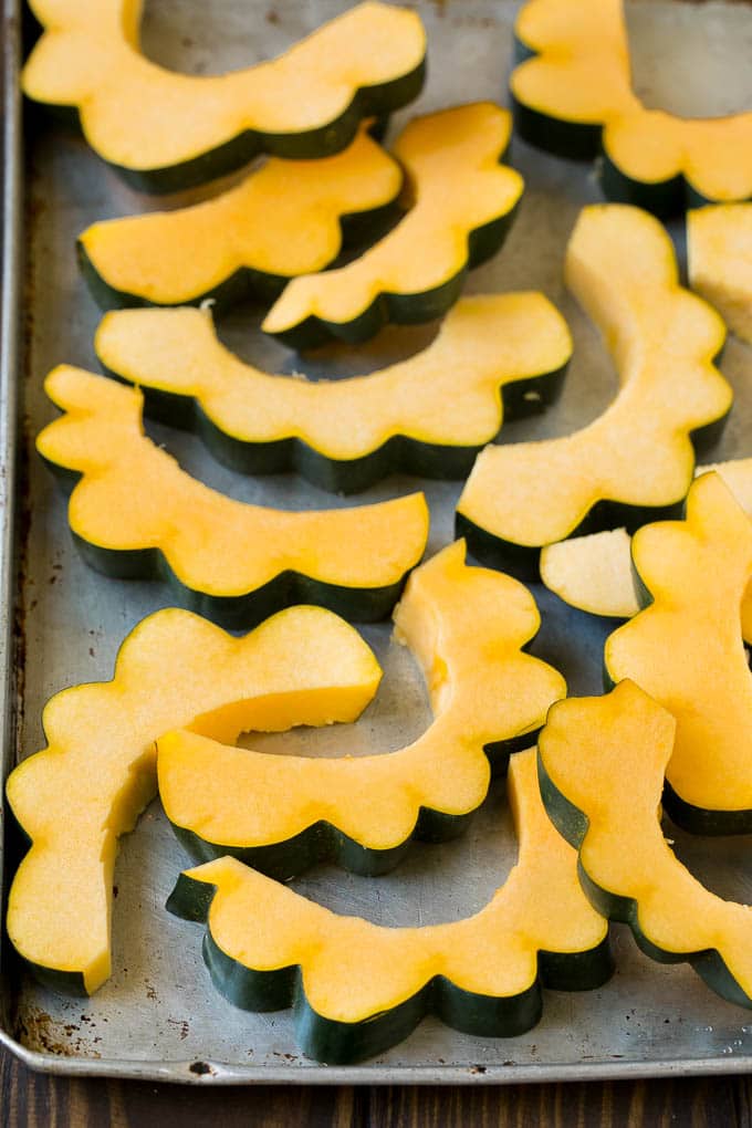 Roasted Acorn Squash | Acorn Squash Recipe #squash #winter #sidedish #dinner #sadud Sliced acorn squash on a sheet pan.
