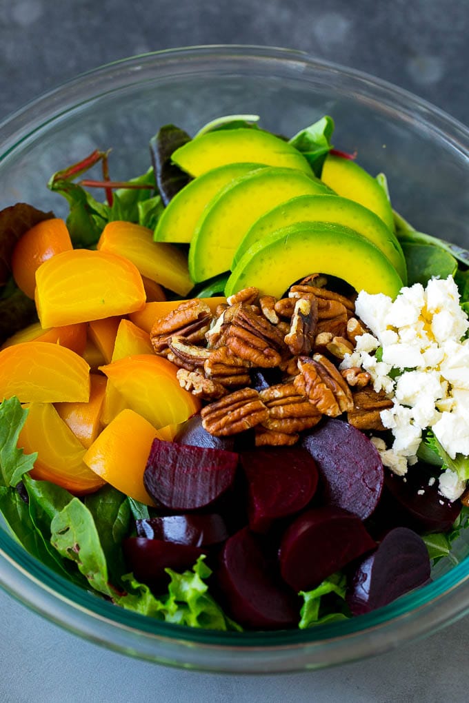 Beet Salad Recipe #beets #avocado #feta #salad #dinner #sadud Red and yellow beets, salad greens, feta cheese, avocado and pecans in a bowl.
