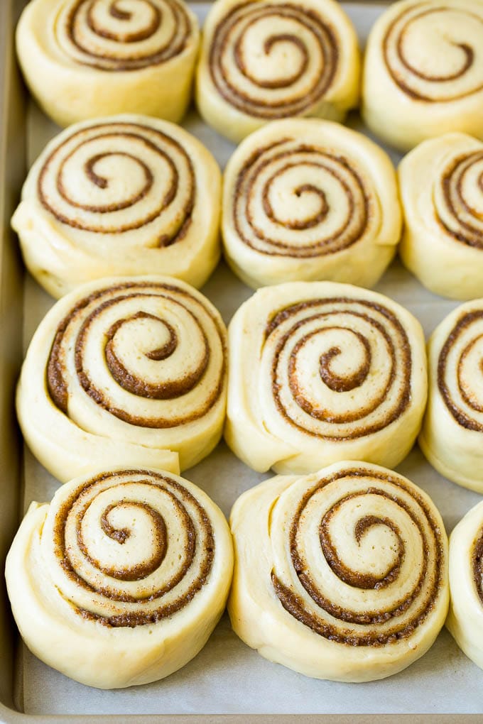 Cinnamon Rolls Recipe | Cinnamon Buns #cinnamon #rolls #pastry #breakfast #brunch #sweets #sadud #baking #bread Rolls of dough and filling rising on a sheet pan.