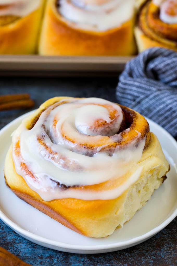 Cinnamon Rolls Recipe | Cinnamon Buns #cinnamon #rolls #pastry #breakfast #brunch #sweets #sadud #baking #bread A frosted cinnamon bun on a serving plate.