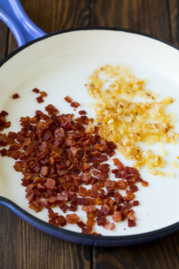 This creamed corn recipe consists of corn kernels simmered in cream sauce, then topped with crispy bacon and fresh herbs. Bacon and onions in a skillet.