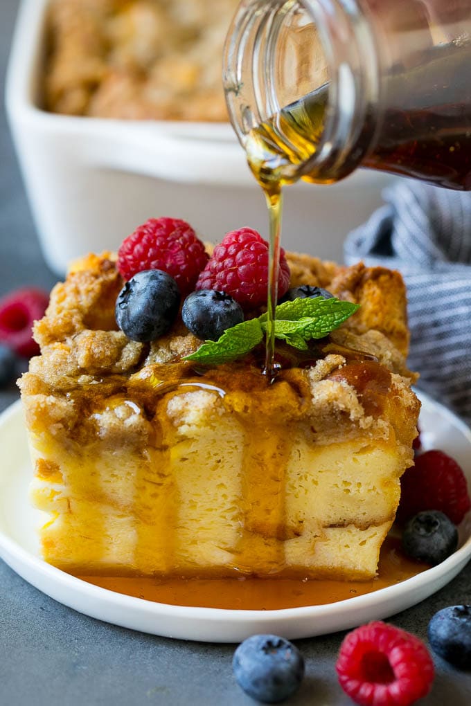 French Toast Casserole Recipe | French Toast Bake #frenchtoast #casserole #breakfast #brunch #sadud #bread A piece of french toast casserole with syrup being poured over the top.