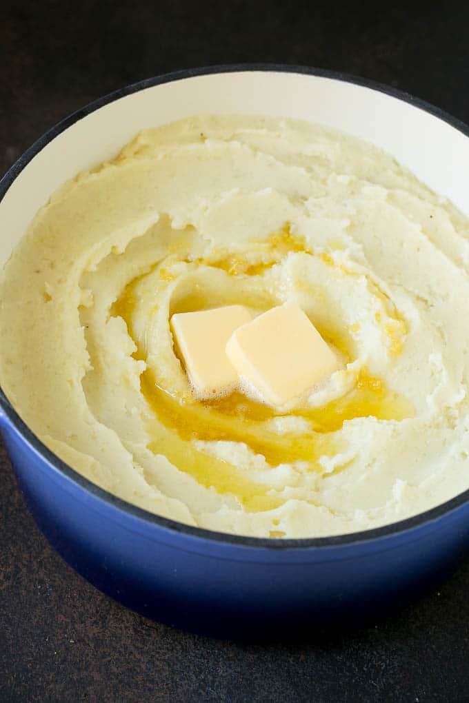Garlic Mashed Potatoes Recipe #garlic #potatoes #mashedpotatoes #sidedish #dinner #thanksgiving #sadud Spuds with melted butter on top.