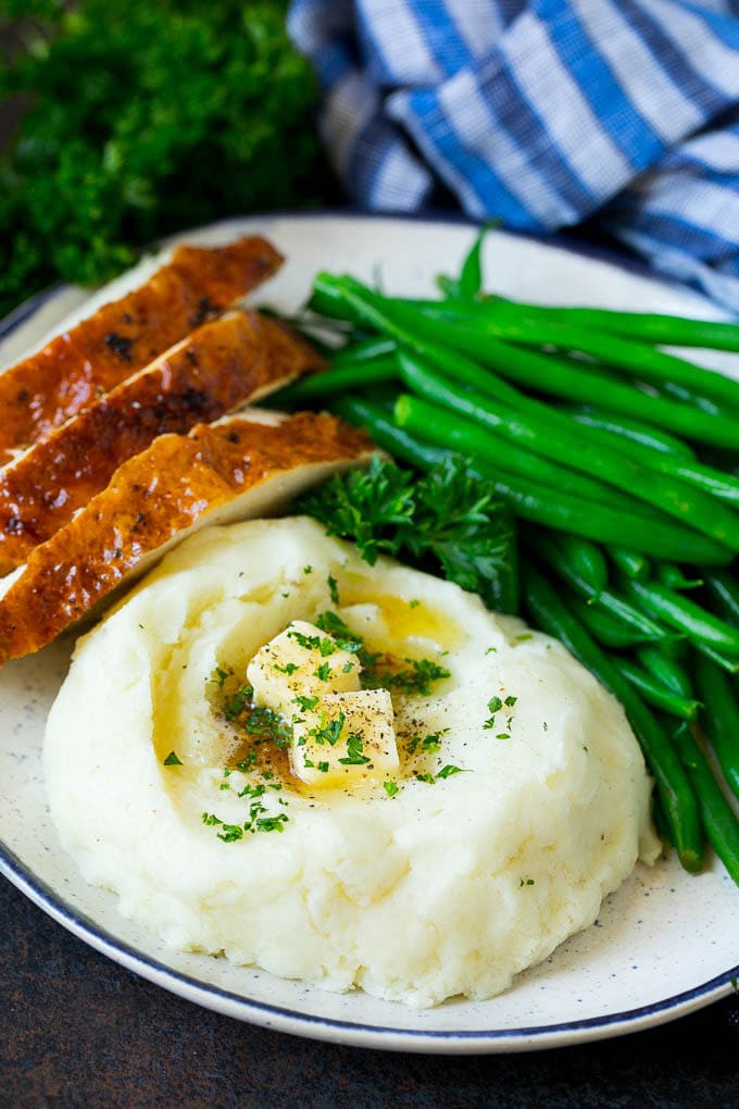 Garlic Mashed Potatoes Recipe #garlic #potatoes #mashedpotatoes #sidedish #dinner #thanksgiving #sadud A plate with garlic mashed potatoes, green beans and sliced turkey.