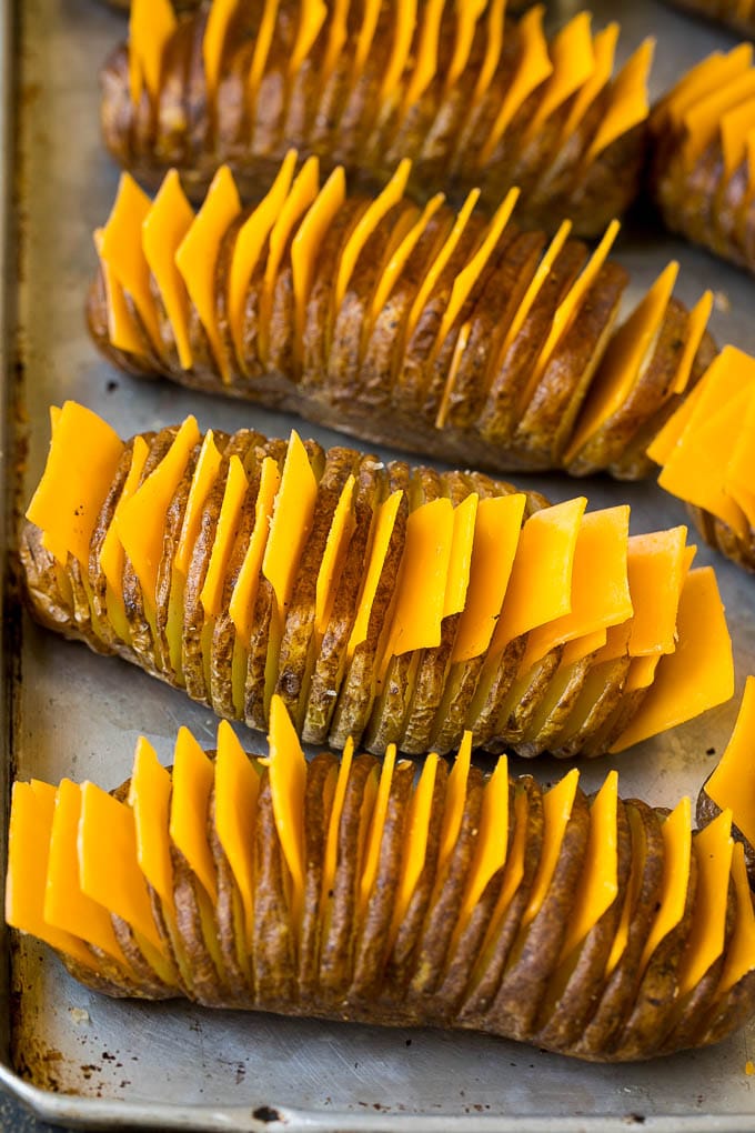 Hasselback Potatoes Recipe #potatoes #bacon #sidedish #cheese #dinner #sadud Thinly sliced potatoes with slices of cheese in between the cuts.