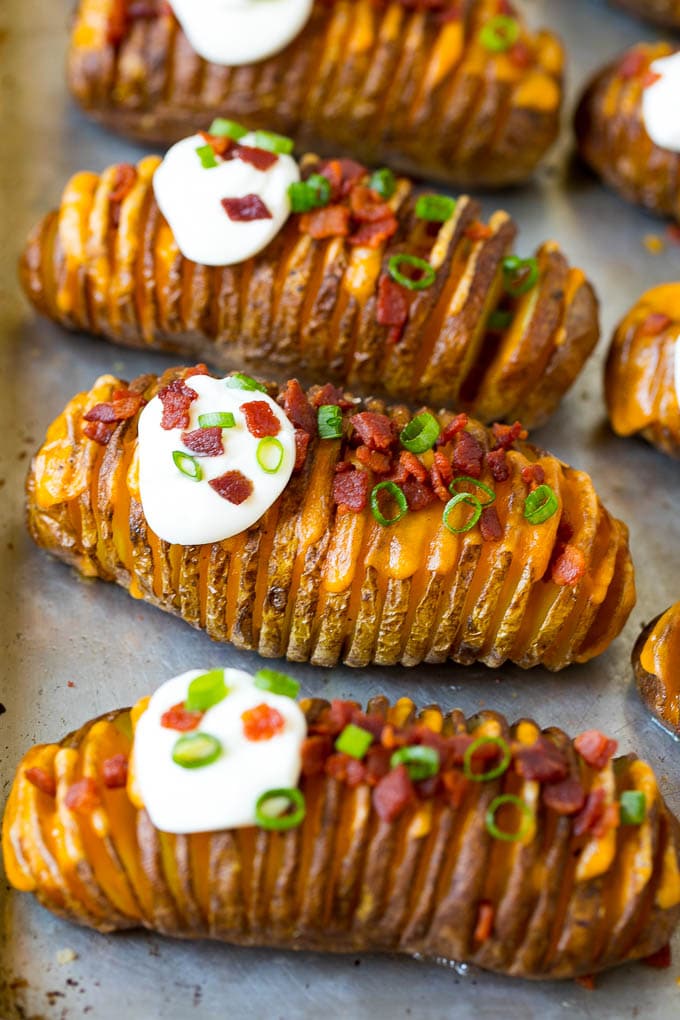 Hasselback Potatoes Recipe #potatoes #bacon #sidedish #cheese #dinner #sadud Hasselback potatoes filled with melted cheese, then topped with bacon, sour cream and green onions.
