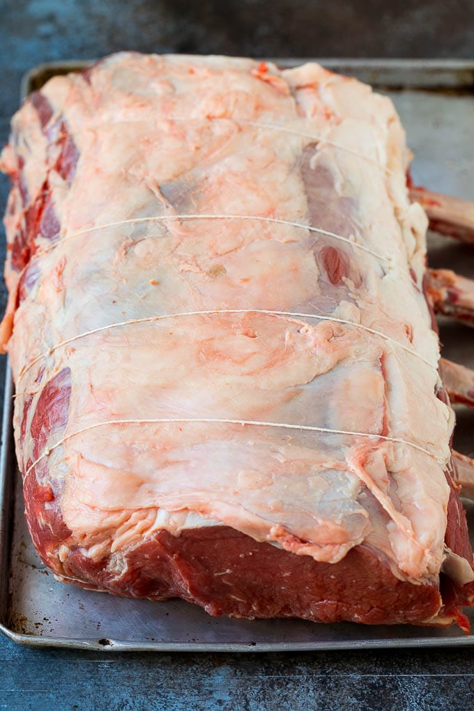 Prime Rib Recipe #primerib #beef #roast #dinner #thanksgiving #christmas #keto #lowcarb #sadud A tied standing rib roast on a sheet pan.