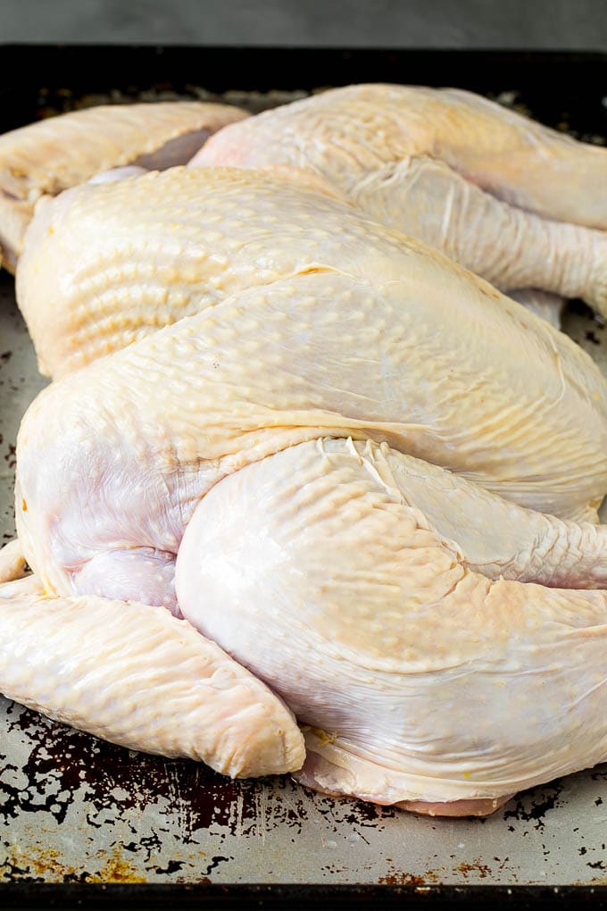 Spatchcock Turkey | Roasted Turkey | Thanksgiving Turkey #turkey #thanksgiving #dinner #fall #christmas #sadud A flattened whole turkey on a sheet pan.