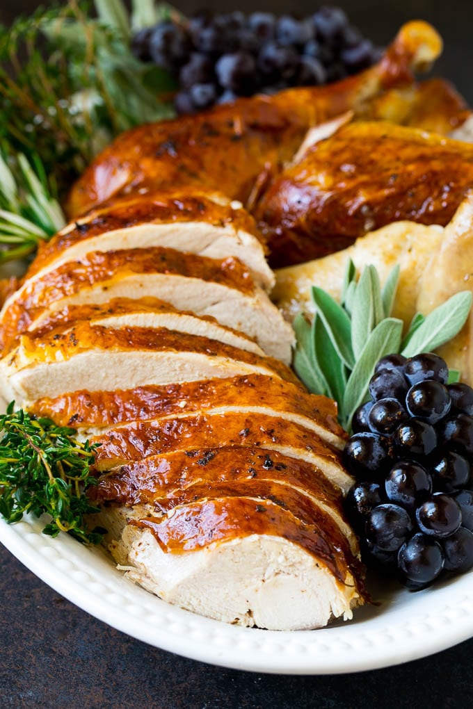 Thanksgiving Turkey Recipe | Roasted Turkey #turkey #thanksgiving #fall #dinner #sadud Sliced Thanksgiving turkey on a serving platter with fresh herbs.