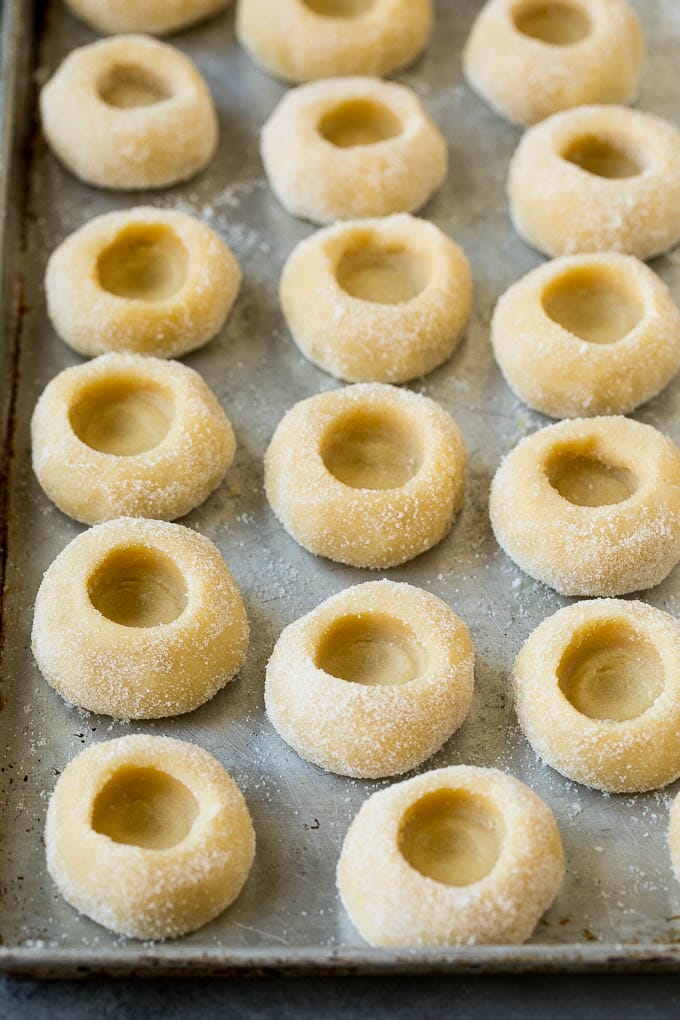 Thumbprint Cookies | Sugar Cookies #cookies #baking #christmas #dessert #sadud Balls of cookie dough with indentations in them.