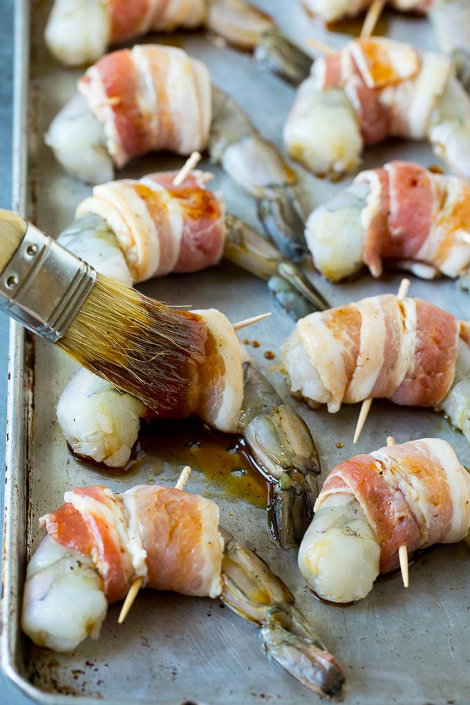 Bacon Wrapped Shrimp Recipe | Bacon Shrimp #shrimp #bacon #appetizer #dinner #sadud #seafood A basting brush applying sauce to shrimp.
