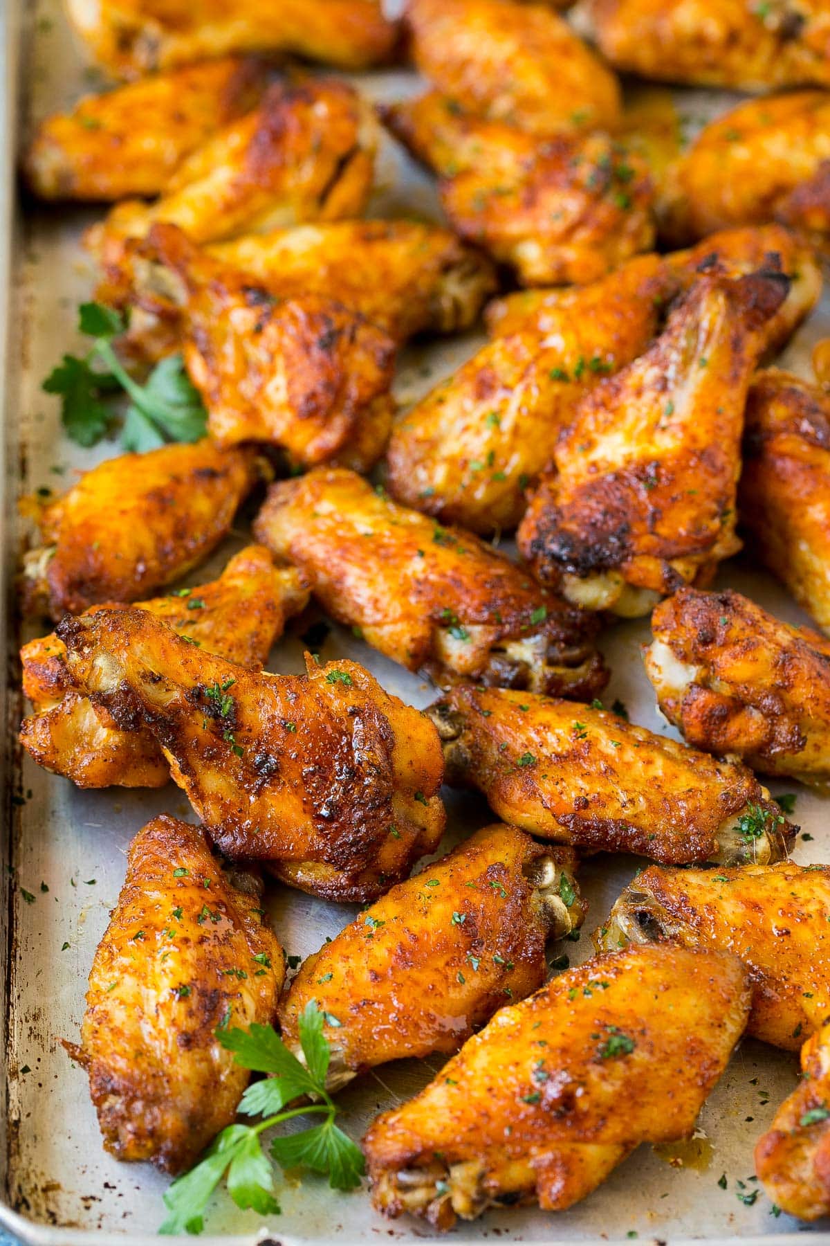 A tray of cooked chicken garnished with parsley.