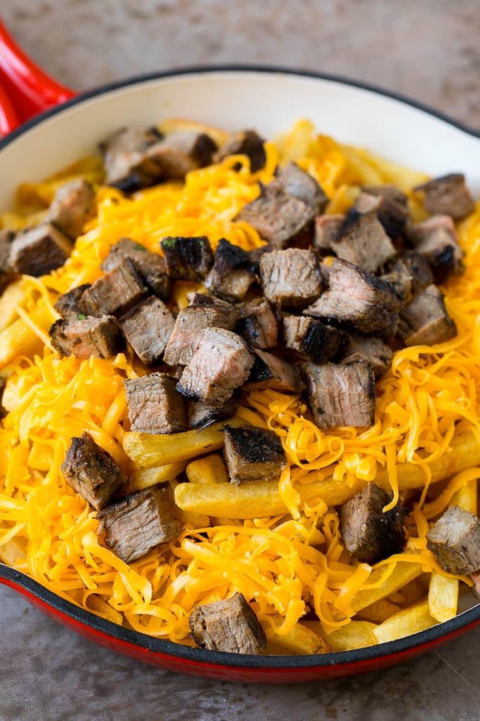Carne Asada Fries Recipe | Steak Fries #fries #frenchfries #steak #salsa #avocado #cheese #dinner #appetizer #sadud French fries topped with shredded cheese and diced steak.
