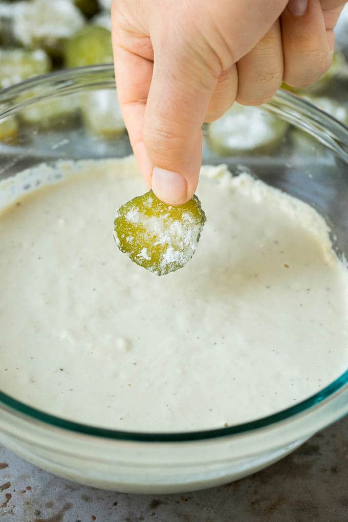 Fried Pickles Recipe #pickles #appetizer #snack #sadud A slice being dipped into a bowl of beer batter.