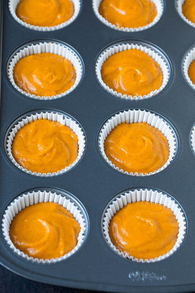 Pumpkin Cupcakes Recipe | Pumpkin Cake #cake #cupcakes #pumpkin #frosting #baking #fall #thanksgiving #sadud Batter inside paper cups in a muffin tin.