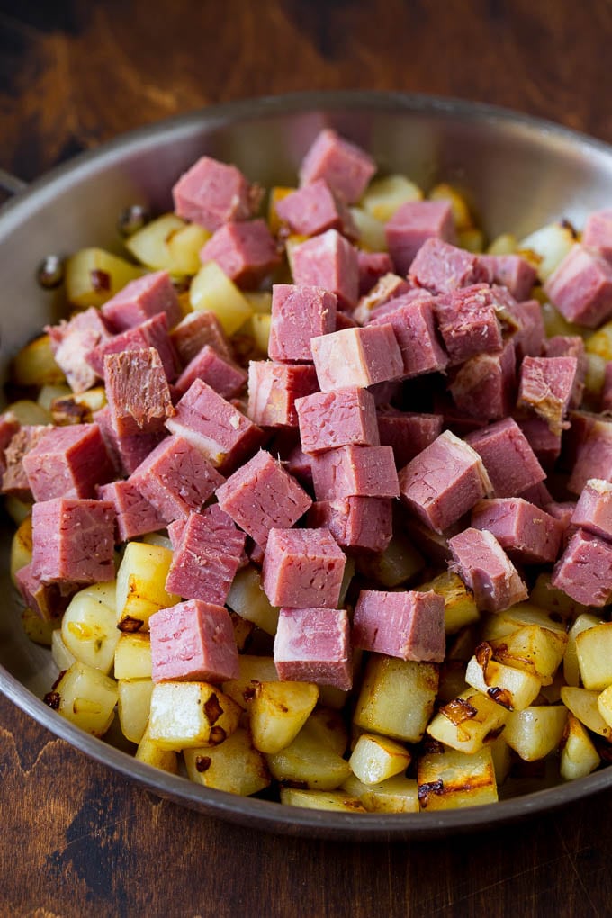 Corned Beef Hash Recipe #hash #cornedbeef #stpatricksday #breakfast #brunch #potatoes #sadud Cubed corn beef on top of cooked potatoes.