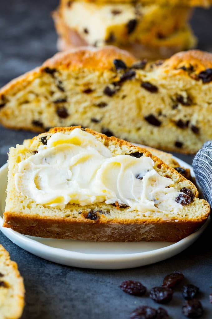 Irish Soda Bread Recipe #bread #baking #stpatricksday #sidedish #sadud A slice of Irish soda bread with butter spread on it.