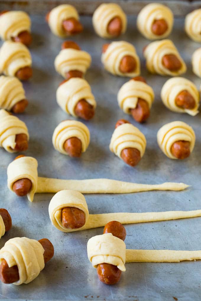 Pigs in a Blanket Recipe #hotdogs #appetizer #snack #comfortfood #sadud Hot dogs being rolled up in dough.