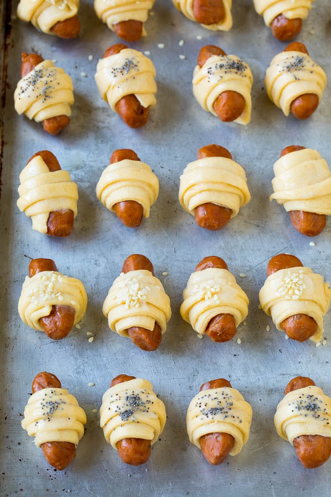 Pigs in a Blanket Recipe #hotdogs #appetizer #snack #comfortfood #sadud Mini hot dogs wrapped in crescent dough and topped with seeds.