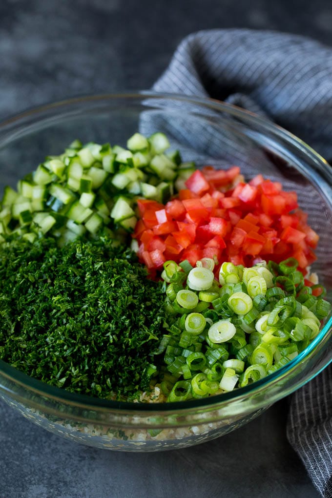 Tabbouleh Salad | Tabouli #salad #wheat #tomatoes #cucumber #healthy #sidedish #dinner #sadud A bowl of bulgur topped with herbs, tomatoes and cucumber.