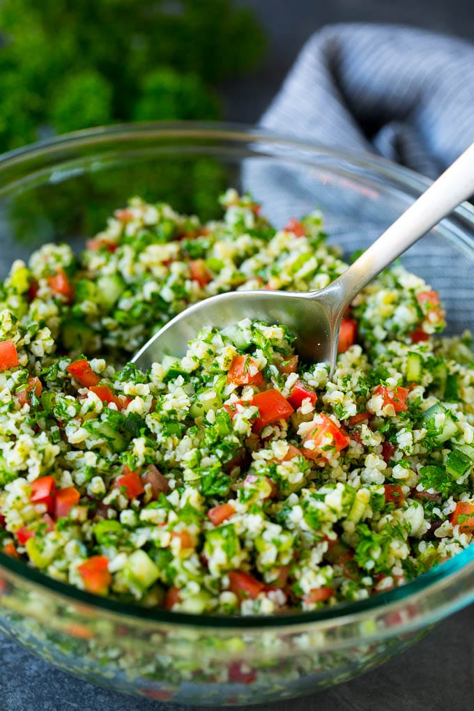 Tabbouleh Salad | Tabouli #salad #wheat #tomatoes #cucumber #healthy #sidedish #dinner #sadud A bowl of tabbouleh with a serving spoon in it.