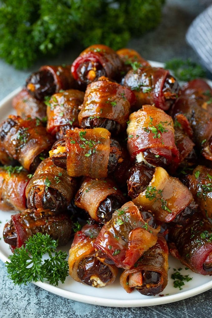 Bacon Wrapped Dates #appetizer #bacon #dates #cheese #sadud A plate of bacon wrapped dates stuffed with goat cheese.