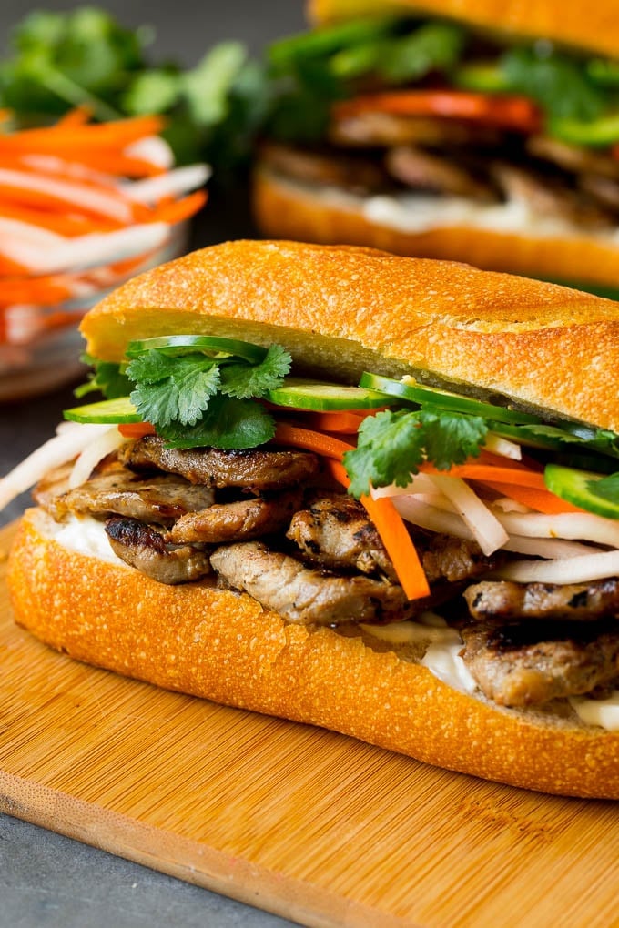 A bahn mi sandwich layered with pork, pickled vegetables and herbs.