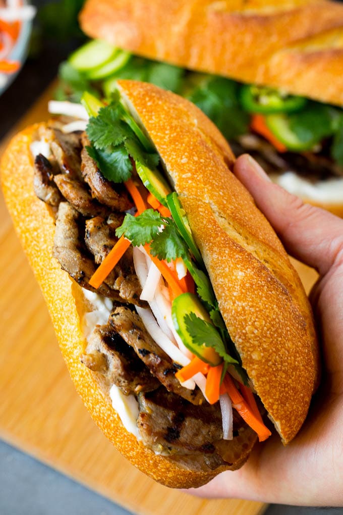 Bahn Mi Sandwich Recipe #sandwich #pork #lunch #dinner #sadud A hand holding a pork banh mi sandwich.