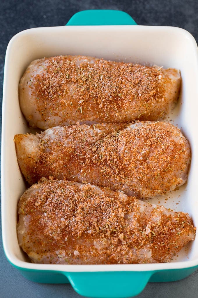 Baked Chicken Breast Recipe #chicken #dinner #sadud Chicken coated in seasonings in a baking dish.