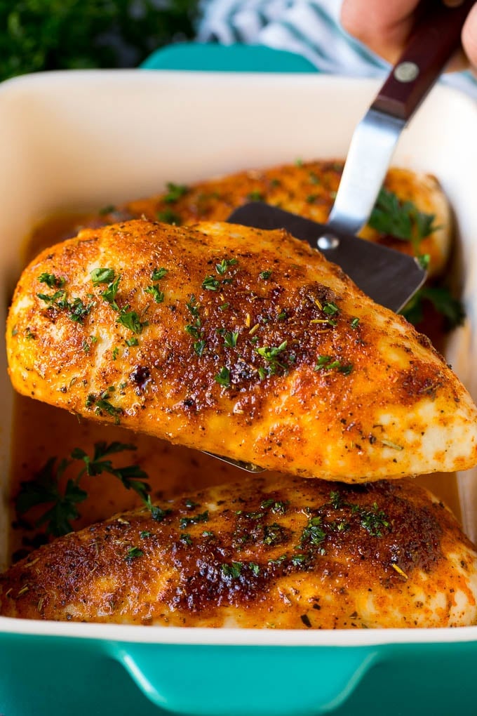 Baked Chicken Breast Recipe #chicken #dinner #sadud A spatula serving up a portion of roasted chicken breast.