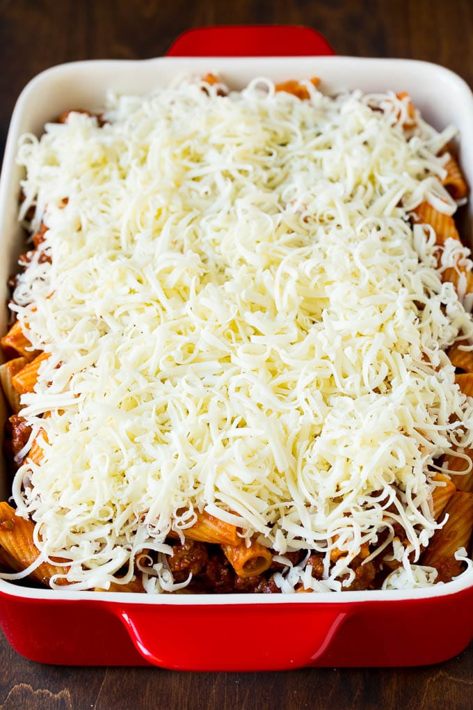 Baked Rigatoni Pasta #pasta #dinner #italianfood #groundbeef #sadud #casserole A pan of pasta in sauce topped with shredded cheese.