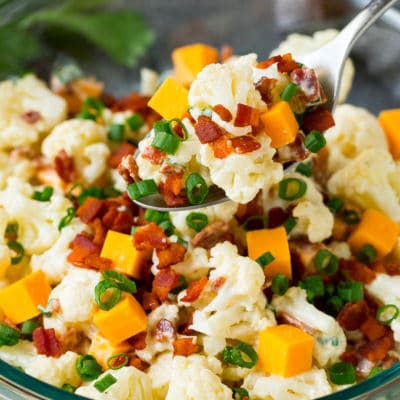 A spoon serving up a portion of cauliflower salad.