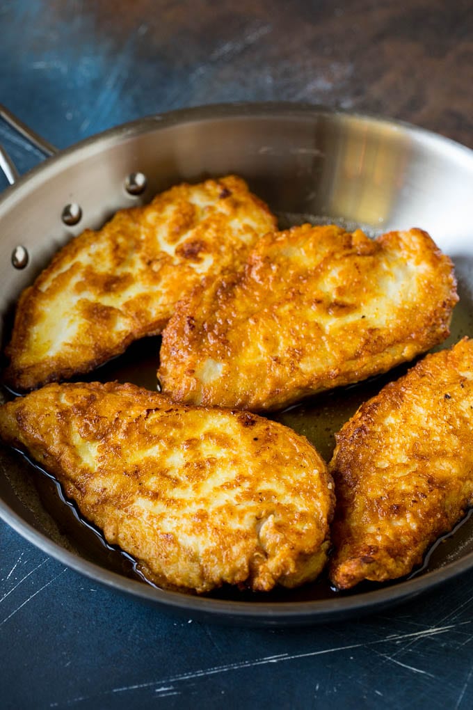 Chicken Francese Recipe #chicken #lemon #dinner #sadud Battered and pan fried chicken cutlets in a pan.