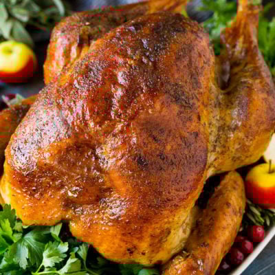 A dry brined turkey garnished with fresh herbs and cranberries.