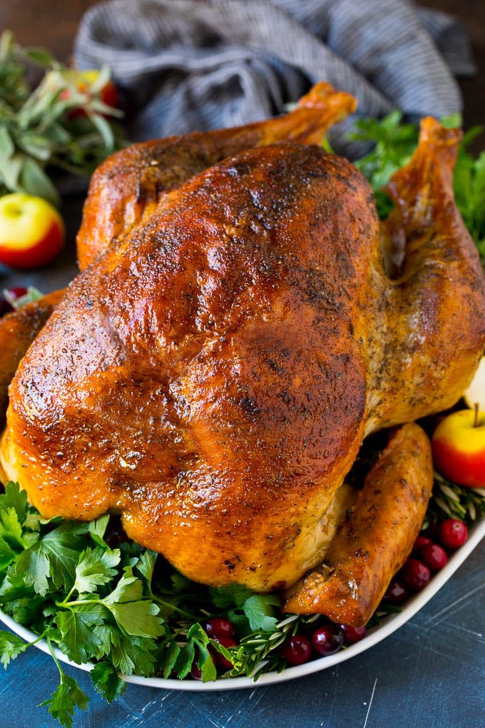 This dry brined turkey is coated in a blend of salt, herbs and spices, then roasted to golden brown perfection. A dry brined turkey garnished with fresh herbs and cranberries.
