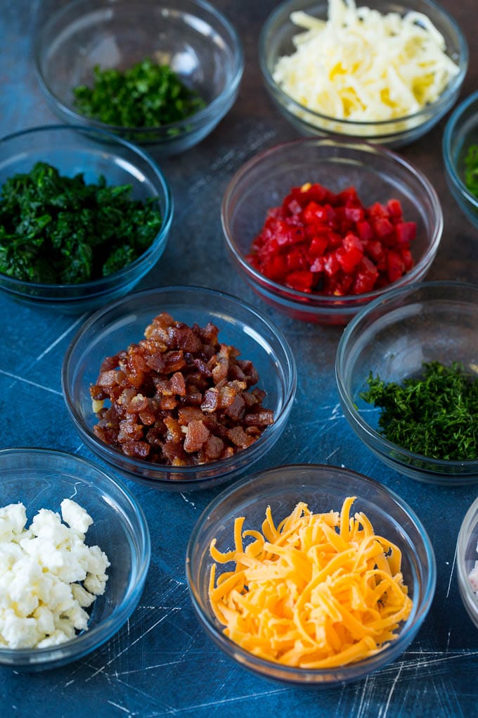 Mini Quiche Recipe #eggs #breakfast #brunch #appetizer #sadud Bowls of assorted flavorings for quiche.