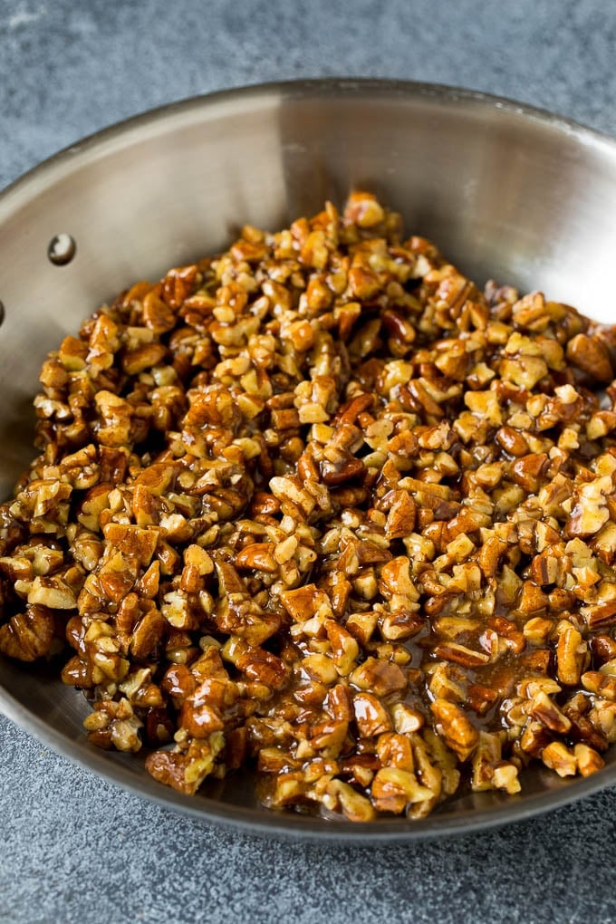 This pecan pie cheesecake is a creamy brown sugar cheesecake topped with a rich and decadent pecan sauce. Pecan brown sugar topping in a skillet.