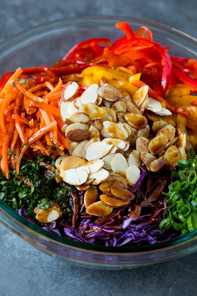 Asian Slaw Recipe #salad #slaw #sidedish #sadud Homemade dressing poured over Asian coleslaw.