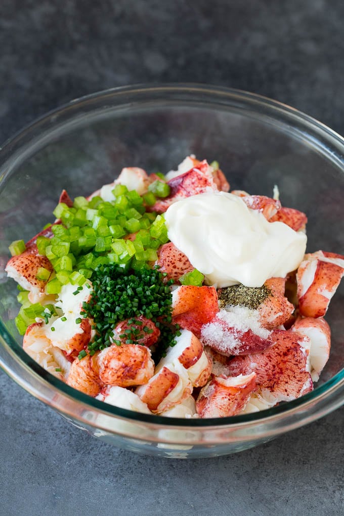 Lobster rolls stuffed with creamy lobster salad in a toasted bun. #lobster #sadud Lobster, chives, celery and mayonnaise in a bowl.
