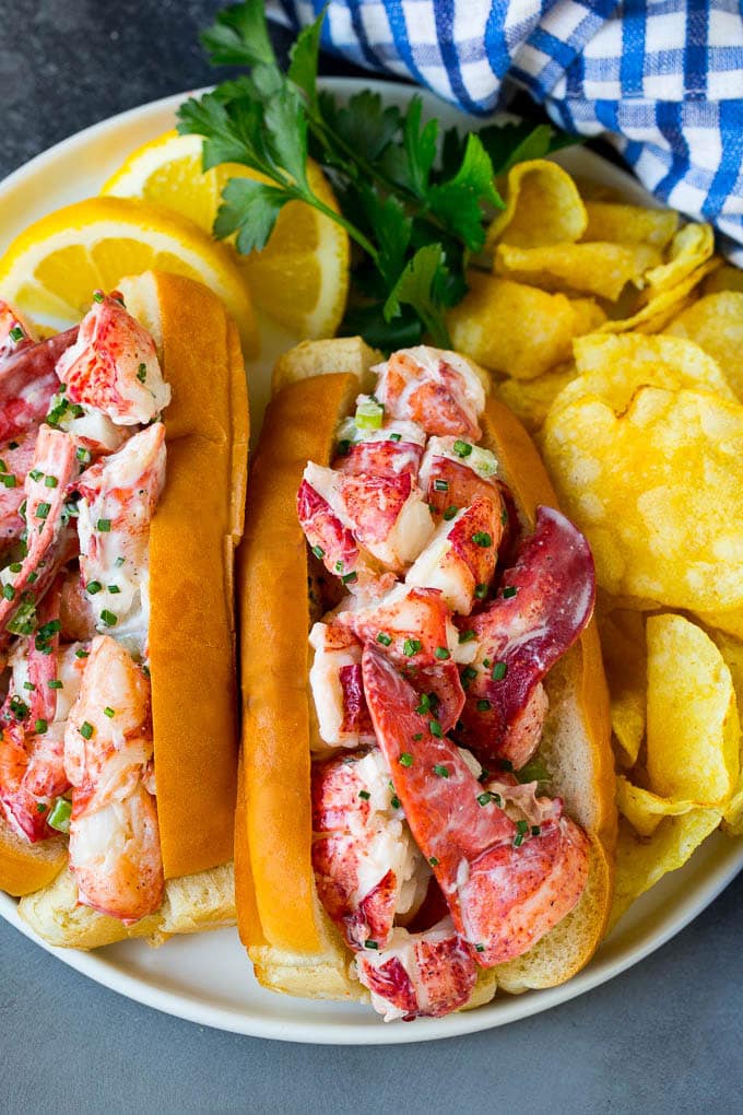 Lobster rolls stuffed with creamy lobster salad in a toasted bun. #lobster #sadud A lobster roll filled with a creamy seafood mixture and served with chips.
