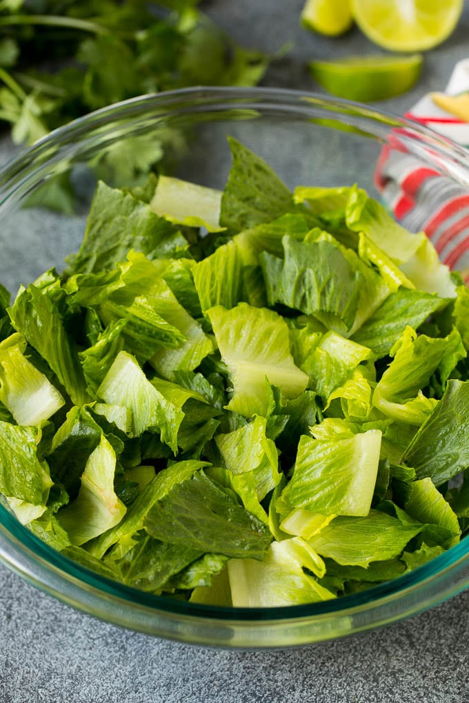 Mexican Salad Recipe #salad #corn #beans #avocado #tomatoes #sadud Chopped romaine lettuce in a bowl.