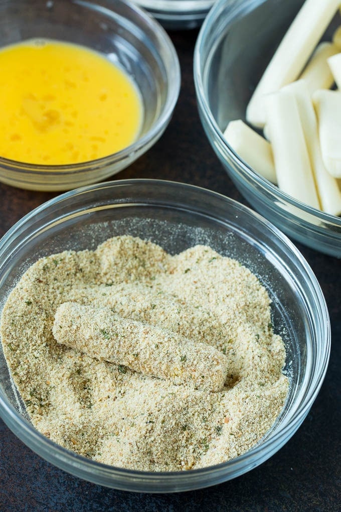Mozzarella Sticks Recipe #cheese #appetizer #sadud Cheese in a bowl of seasoned breadcrumbs.