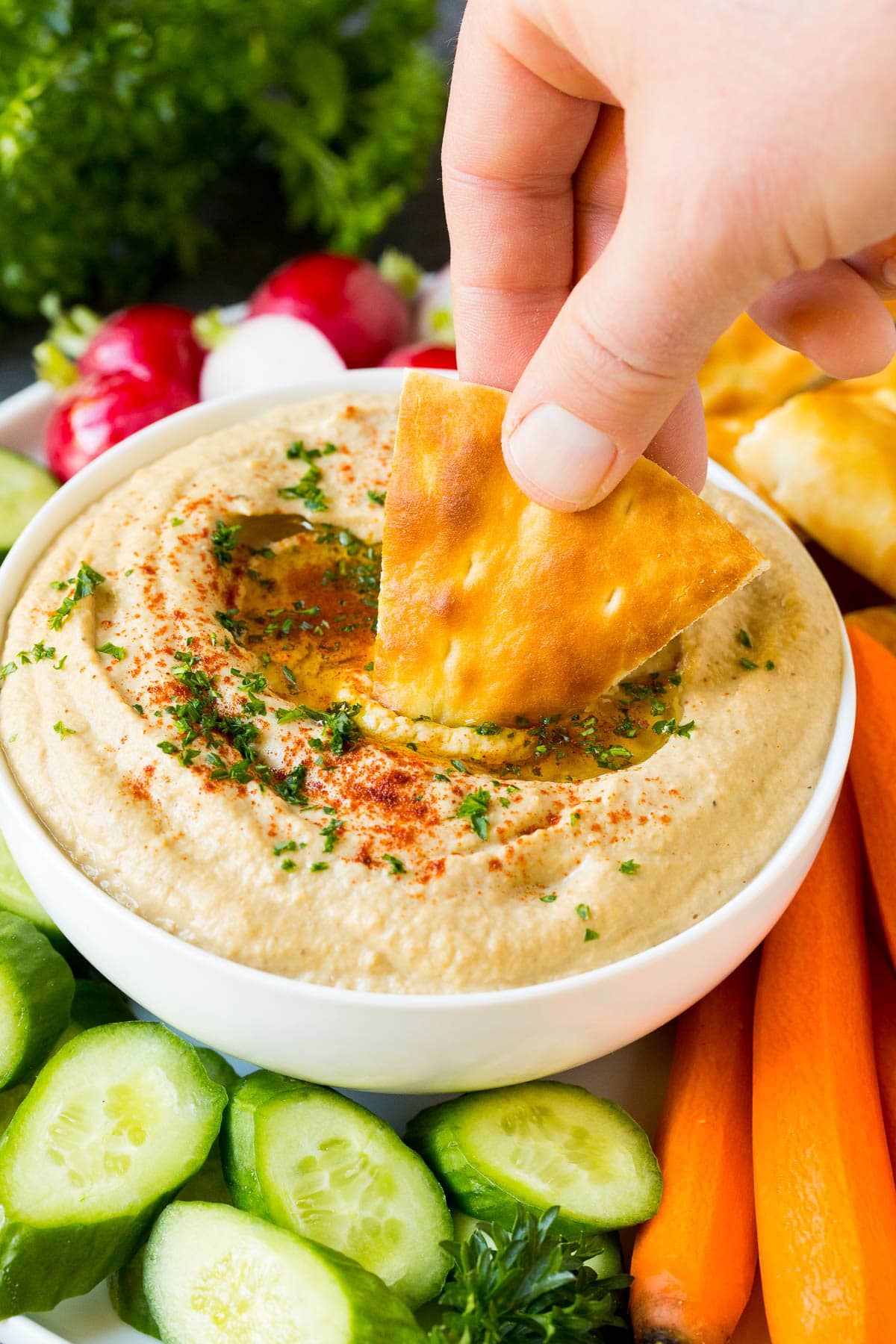 Baba Ganoush Recipe | Eggplant Dip #eggplant #appetizer #dip #healthy #glutenfree #lowcarb #sadud A hand dipping pita bread into baba ganoush.