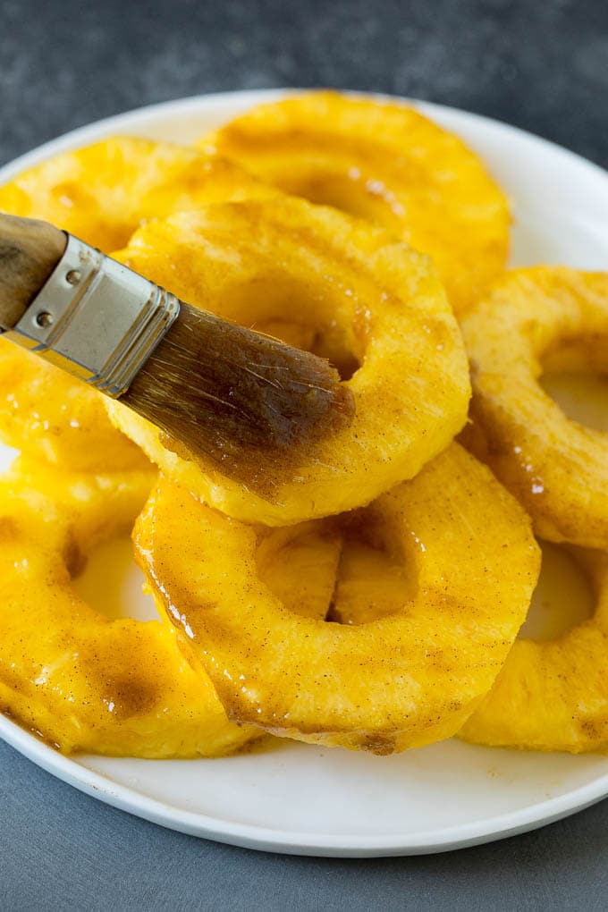 Brown sugar grilled pineapple is a quick and easy side dish or dessert! A brush coating fruit slices with butter and brown sugar.