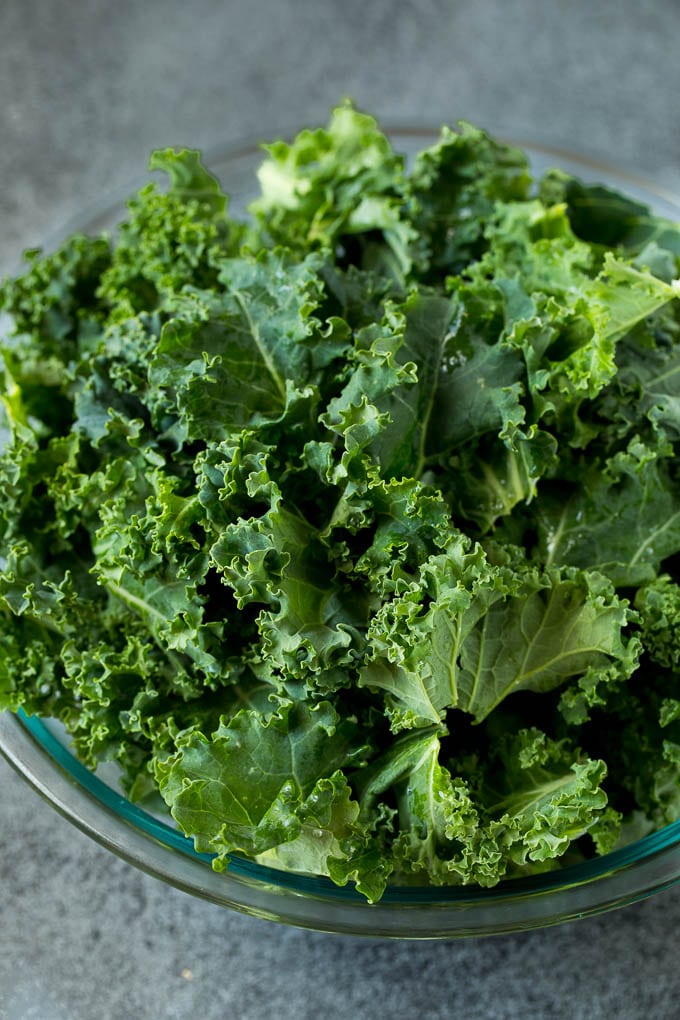 Sauteed kale flavored with olive oil and garlic, a quick and easy side dish! #kale #sadud Chopped kale in a mixing bowl.